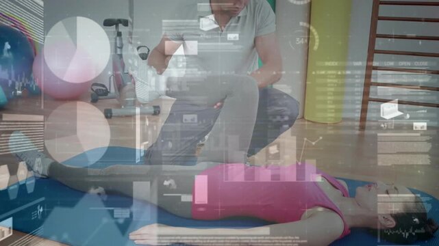 Trainer lifting client's legs guiding right leg for rehab, charts highlighting joint over blue mat