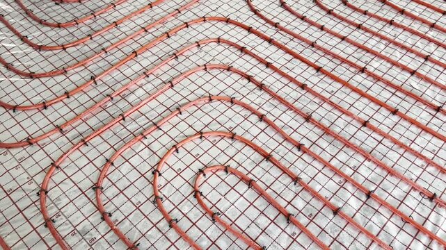 Installation of underfloor heating system, above view. Camera moving right and up