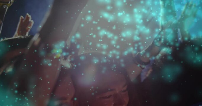 Cheering crowd raising hands at concert, wearing festival clothes and wristbands, turquoise overlay