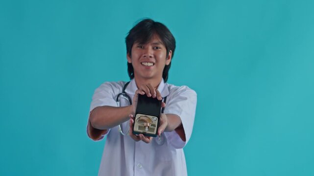 Smiling medical professional holding  digital hearing aid device