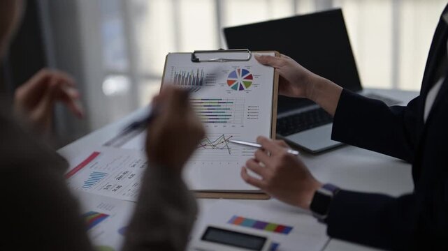 Business people analyzing financial graphs during office meeting