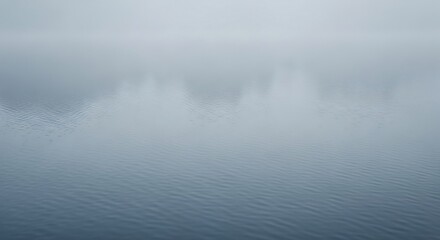 Fototapeta premium Misty Morning Over Calm Lake Reflecting Trees and Sky.