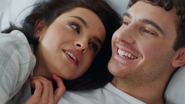 Close up happy Caucasian couple man woman talking on bed home bedroom cuddling female male smiling relationship romance feeling sweetheart honeymoon faces girlfriend boyfriend love togetherness bond