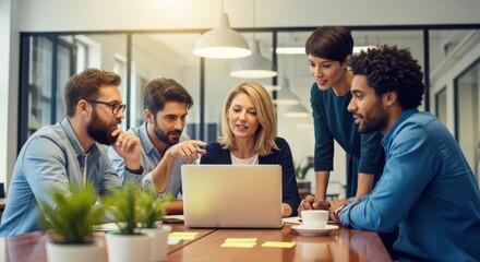 Diverse group of professionals collaborates around a laptop during a meeting in a bright office setting