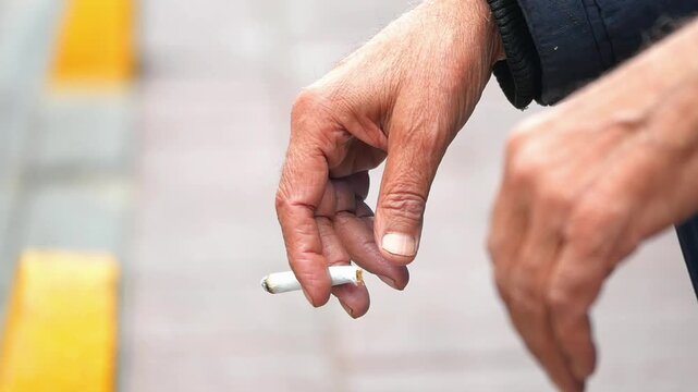 Hands holding a cigarette on the street
