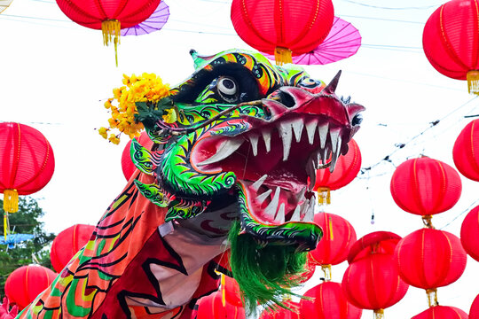 Close up view of a Chinese dragon dance performance. A traditional symbol of prosperity, often seen in festivals, Chinese New Year, and cultural celebrations. half. low angle. red lanterns, lantern. 