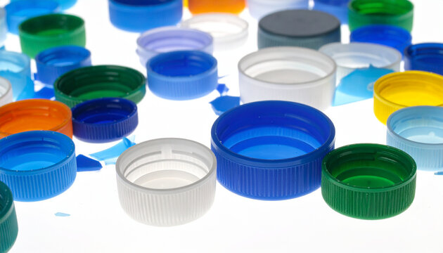 Colorful plastic bottle caps arranged on a bright white surface