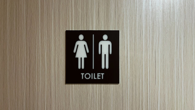 side view of unisex restroom sign on wooden wall or door. brown, black, white. Public toilet sign showing facilities for male or female. icon. 
