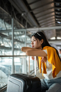Unhappy young woman traveler disappointed with flight delay or cancelation while waiting at airport terminal, female tourist upset after receiving bad news when sitting at airline lounge.