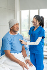 A male cancer patient on bed receives IV therapy while a female doctor offers care encouragement and updates on his test results providing support and discussing health progress