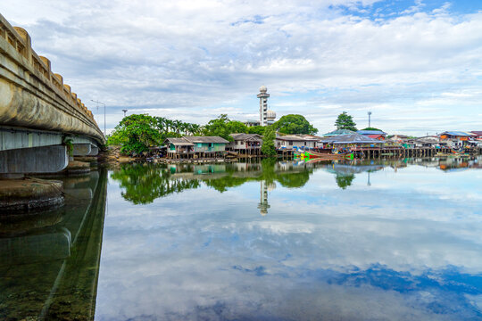 Local fishing village along the Bang Nara River with kolae boats colorful with a mosque in the background in the evening.