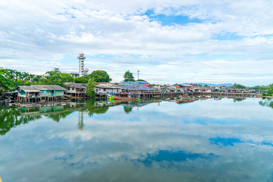 Local fishing village along the Bang Nara River with kolae boats colorful with a mosque in the background in the evening.