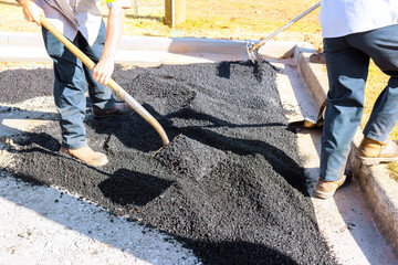 Fototapeta na wymiar Workers lay down asphalt in parking lot
