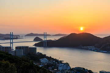 冬の鍋冠山公園から見た女神大橋と夕日　長崎県長崎市　The Megami Bridge and sunset as seen from Nabekanmuriyama Park in winter.. Nagasaki Pref, Nagasaki City. © M・H