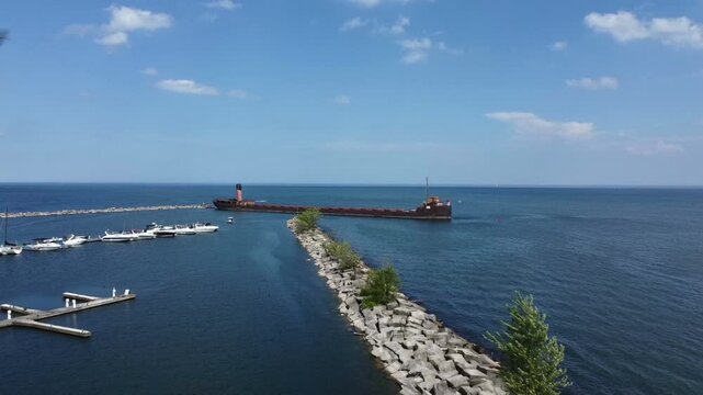 The Ridgetown, a partially sunken bulk freighter in Lake Ontario serving as a breakwater for the marina at the mouth of the Credit River in Port Credit, Mississauga, Ontario, Canada. Aerial drone shot