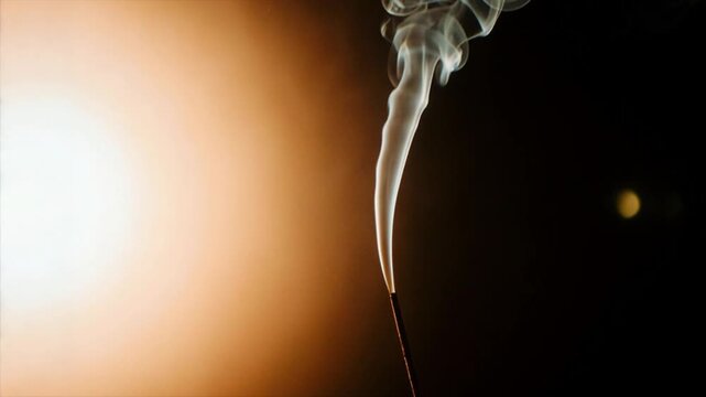 夕日のような暖色の光に包まれた煙の右パン映像