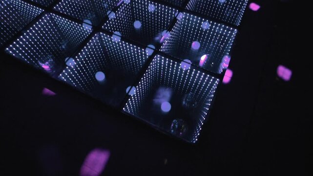 Glowing LED dance floor with illuminated square panels and colored light reflections in dark room, abstract event backdrop