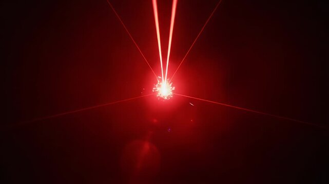Red Laser Light Show - This video depicts a converging fan of red laser beams pointing towards a central point, surrounded by sparks and particles of light.