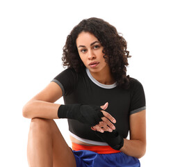 Beautiful African-American boxer applying wrist wrap on white background