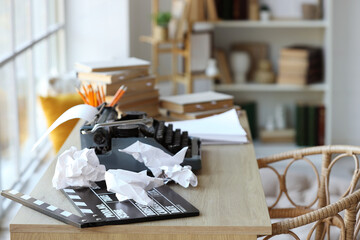 Vintage typewriter with script, movie clapper and crumpled paper on desk in screenwriter's office