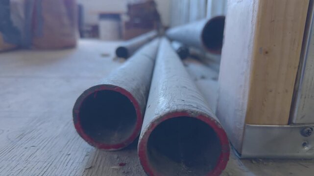 Close-up of stacked sections of CISPI (Cast Iron Soil Pipe) drain pipes in