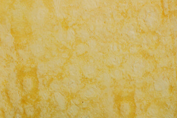 Fototapeta premium Soft, golden-yellow surface with subtle, organic swirls