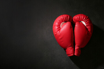 Pair of red boxing gloves on black background