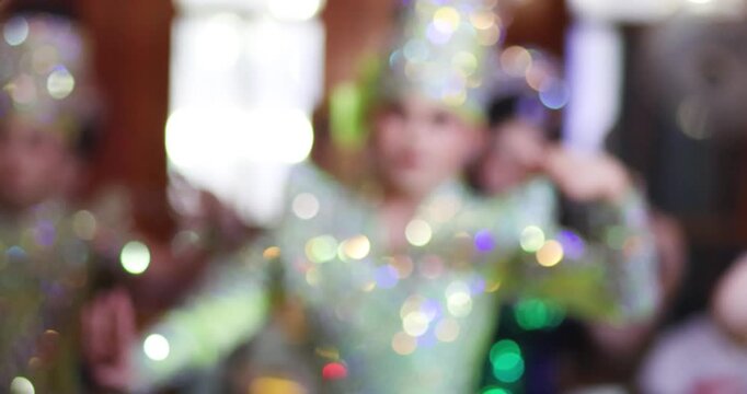 Blurred Thai Likay dancers performing traditional dance on stage with colorful bokeh lights. Cultural performance representing Thai heritage, festival entertainment and nightlife