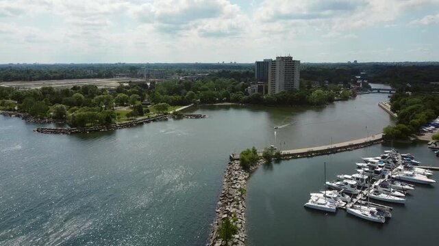 The mouth of the Credit River in Port Credit, Mississauga, Ontario, Canada. Aerial drone shot during a warm summer afternoon looking west.