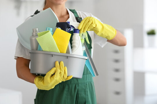 Female janitor with cleaning supplies in office