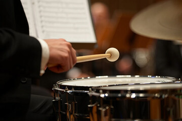 Naklejka premium Jazz Day Orchestral drummer hitting snare drum with mallet close up image