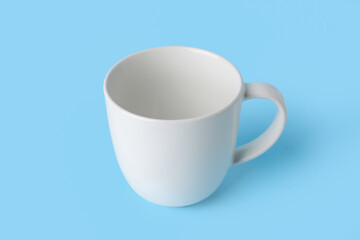 White empty ceramic mug on blue background