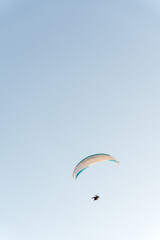 Colorful paraglider soaring above snow capped mountains under a clear blue sky. Scenic alpine landscape creates a powerful adventure and freedom concept perfect for travel and extreme sport themes. © Христя Сидор