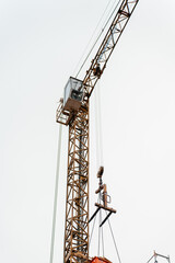 Urban construction scene featuring a historic building covered in scaffolding with a crane above, development and architectural transformation.