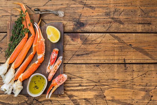 Premium red kamchatka crab legs steamed and cleaned with butter sauce on dark wooden background seafood delicacy