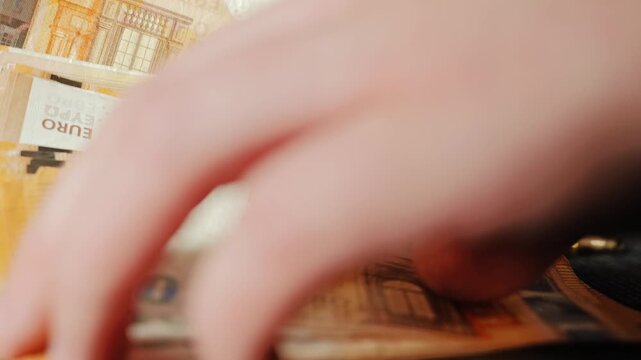 Hand takes euro banknotes as bullets and bitcoin coins remain on dark floor