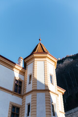 Obraz premium Elegant European buildings with classic architecture set against scenic mountains and clear blue sky. Charming urban atmosphere with historic details and picturesque alpine landscape perfect for