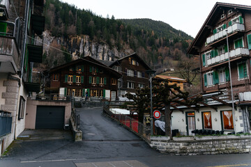 Fototapeta premium Charming alpine village with traditional wooden chalets nestled in the mountains. Scenic European countryside landscape perfect for travel, tourism, and peaceful getaway concepts.