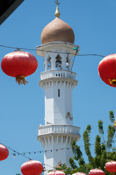 Chinese Lanterns Over Kapitan Keling Mosque in George Town Penang. his scene captures a pensive, harmonious blend of faiths, symbolizing the raw beauty of multicultural integration.