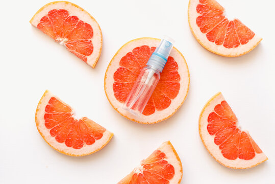 slices of grapefruit. A bottle of perfume against a background of grapefruits. Grapefruits and an empty bottle. Grapefruit perfume.
