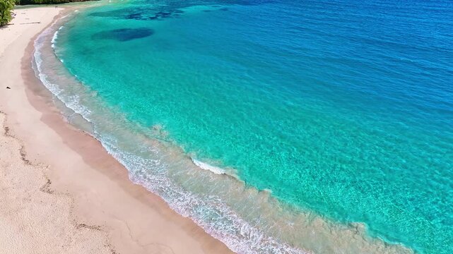 Aerial view of sandy sea beach with waves. Summer seascape from the air. Amazing tropical backdrop. Rincon Beach in the Dominican Republic. Sea sand beach with turquoise waves. Turquoise on gold.