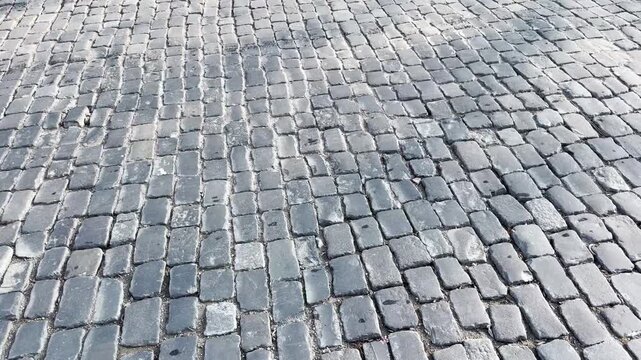 Old grey cobblestone pavement texture, weathered stone street background in historic European style