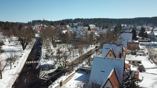 Aerial drone view of snow covered houses and quiet residential street in Ifrane city in the Middle Atlas Mountains of Morocco during winter.
