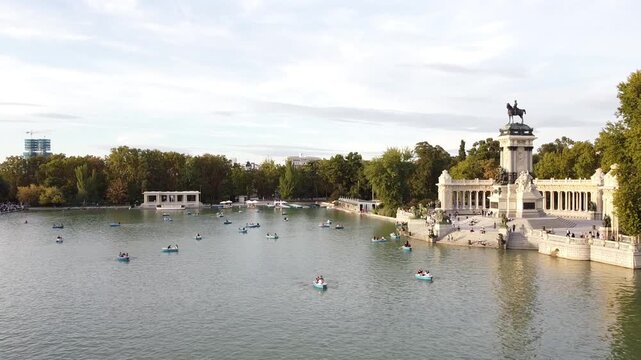 Aerial view of tourists on boats enjoying an autumn day on a great pond in front of monument to Alfonso XII at the Retiro Park (Parque del Buen Retiro) in Madrid, Spain.