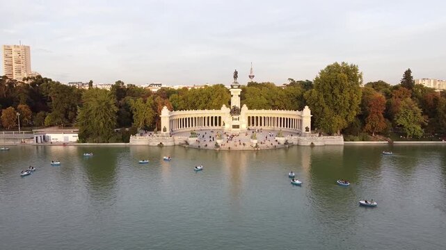 Aerial view of tourists on boats enjoying an autumn day on a great pond in front of monument to Alfonso XII at the Retiro Park (Parque del Buen Retiro) in Madrid, Spain.