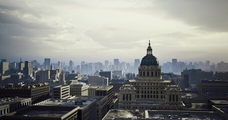 Obraz premium Cinematic dusk skyline with prominent capitol dome and warm shadows, layered rooftops and dramatic cloudscape creating filmic mood, perfect for advertising,