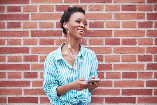 Portrait of relaxed woman using earphones and cell phone