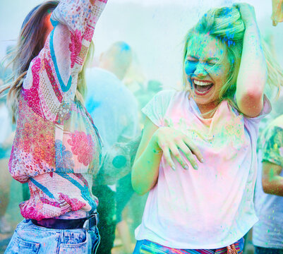 Friends dancing at music festival, holi powder