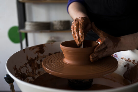 Potter forming clay on a wheel