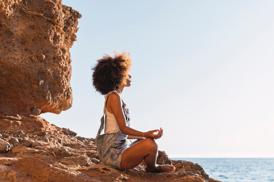Young woman meditating at the beach